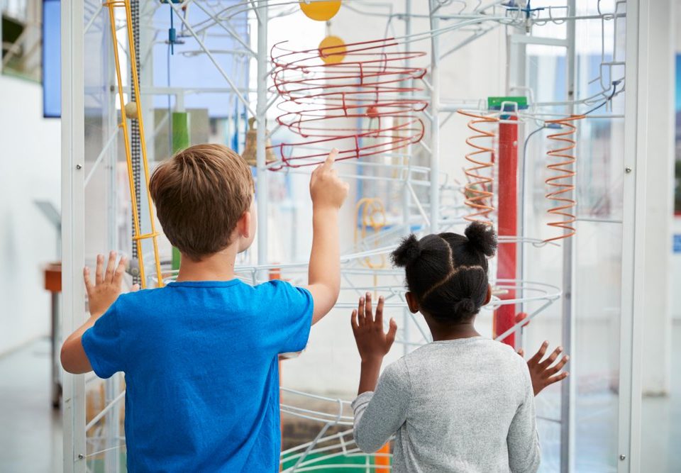 young kids looking at science exhibit