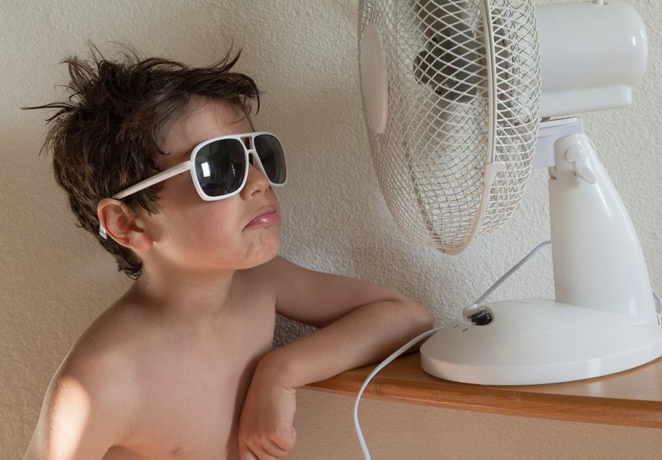 little boy in front of fan