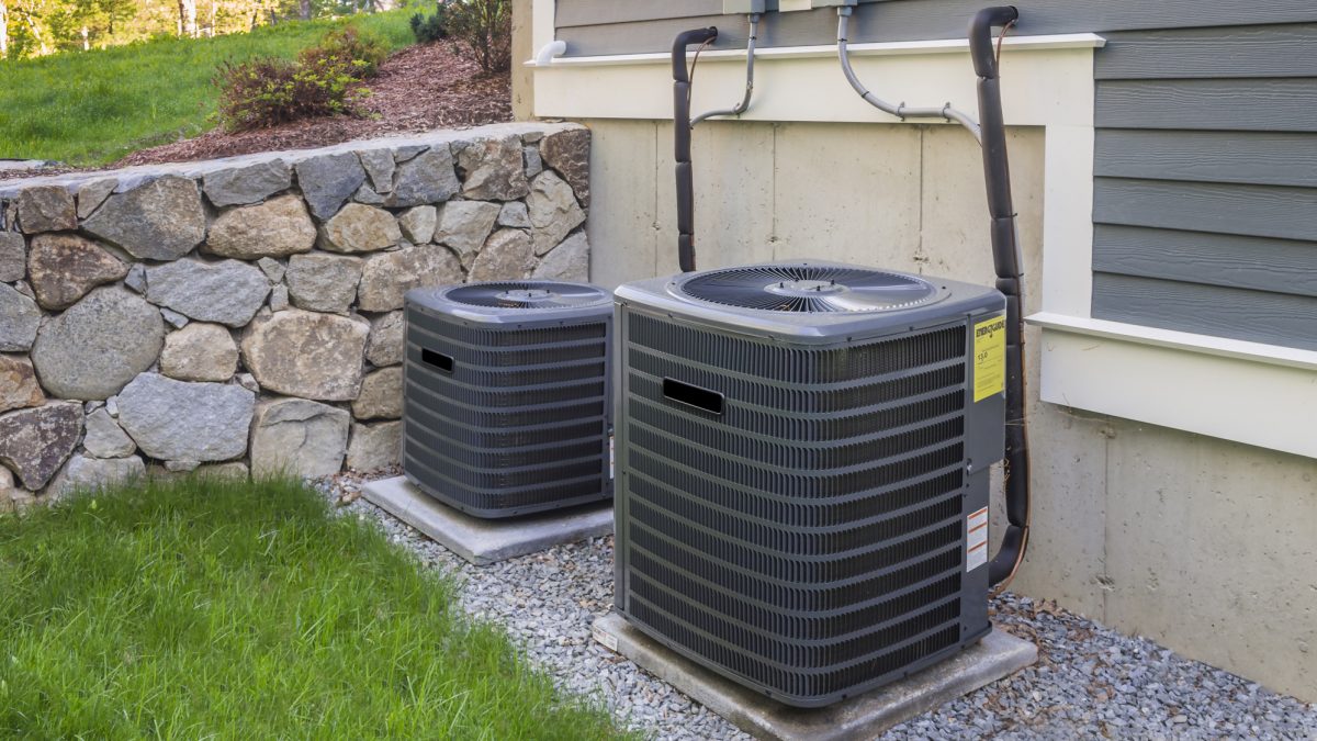 Residential heating and air conditioner compressor units near suburban house