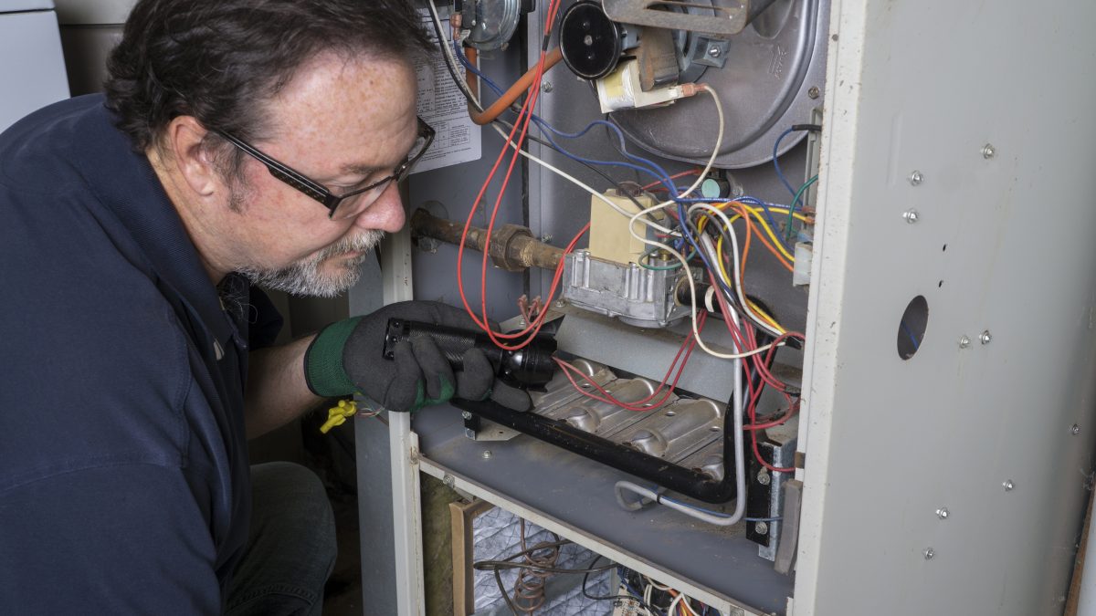 hvac tech conducts heating system repair on a furnace