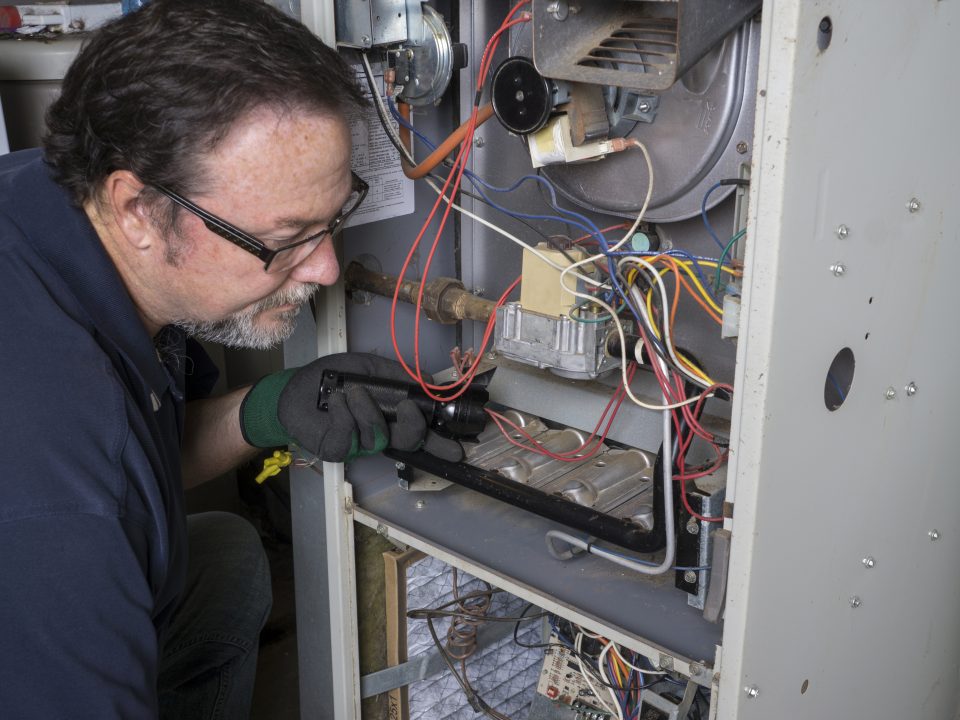 hvac tech conducts heating system repair on a furnace
